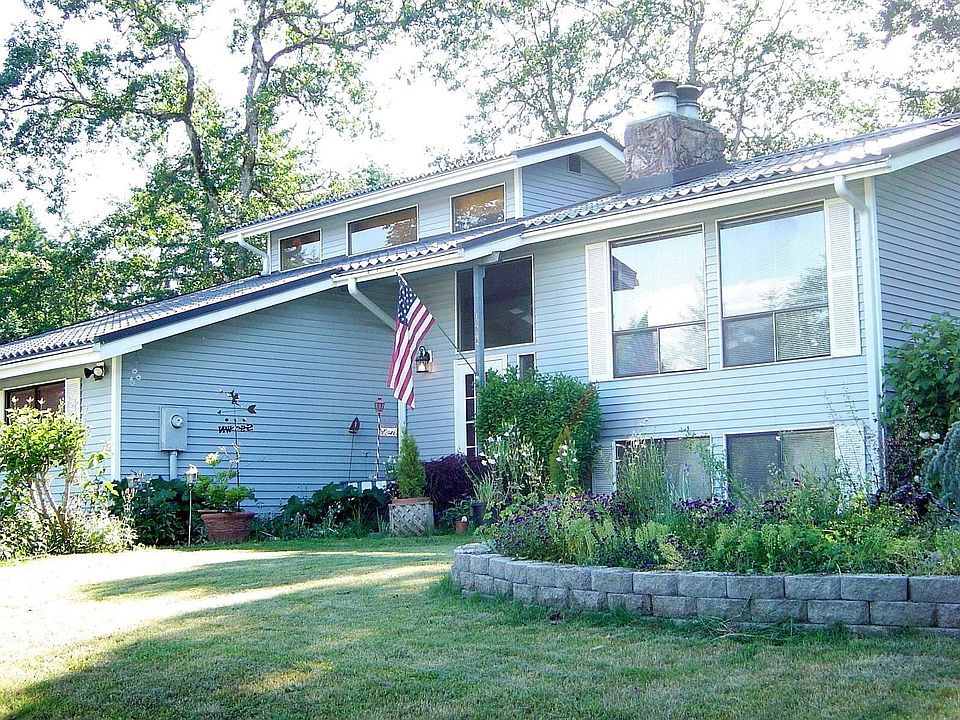 Large corner lot home with multiple planted areas and terraced garden space.