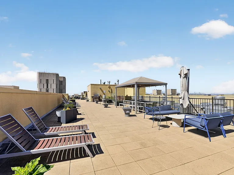 Rooftop terrace with lounge seating, outdoor dining areas, and city views.