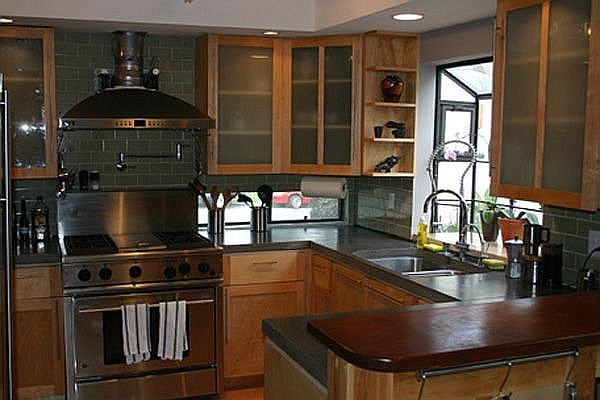 True gourmet kitchen with handcrafted cabinetry, concrete countertops and stai