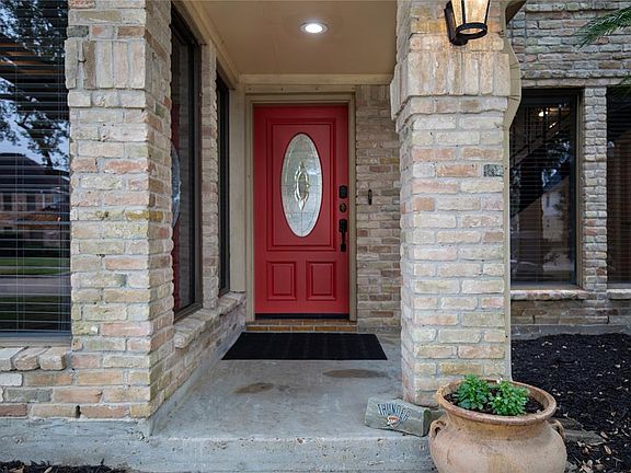 A covered entry leads to the wood and leaded-glass front door.