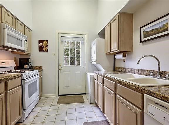 The kitchen has a gas range/oven, dishwasher, microwave, and washer/dryer. The counters are granite, and there is a pantry. This back door leads to a common area and to the reserved parking space that comes with this unit.