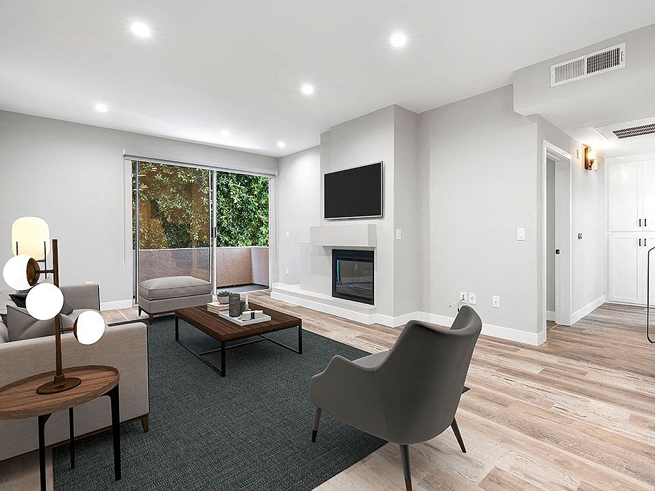 Living Room with hardwood floors, fireplace, and direct patio access.