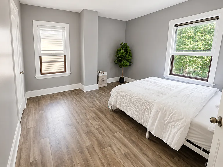 Private bedroom with updated flooring and neutral finishes