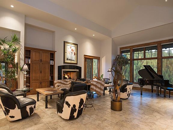 Open living room, high ceilings, large windows. One of four fireplaces.