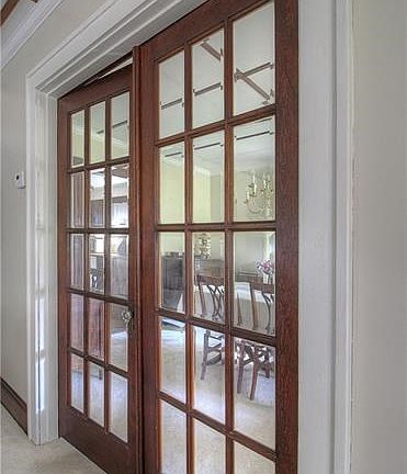 Original 16-panel, beveled glass French Doors are a focal point and offer privacy between the Dining and Living Rooms.