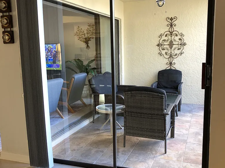 Walk-out lanai with side tables, coffee table, and comfy seating for 4.