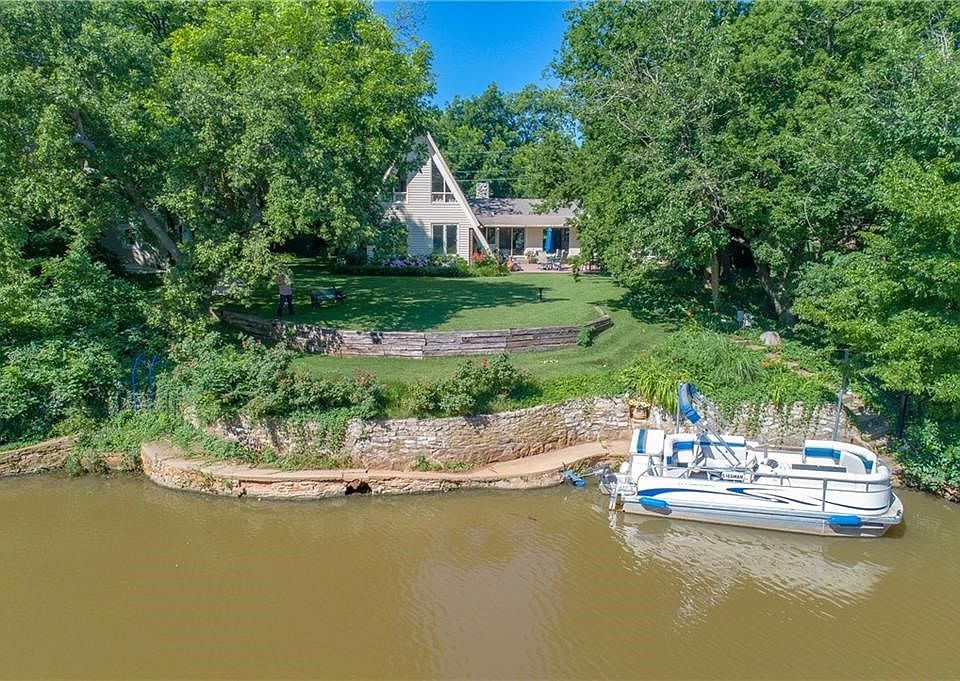 The back of this home shows the lake, retaining wall, and the owner's electric boat. This was after a rain, so it's not as pretty as usual!