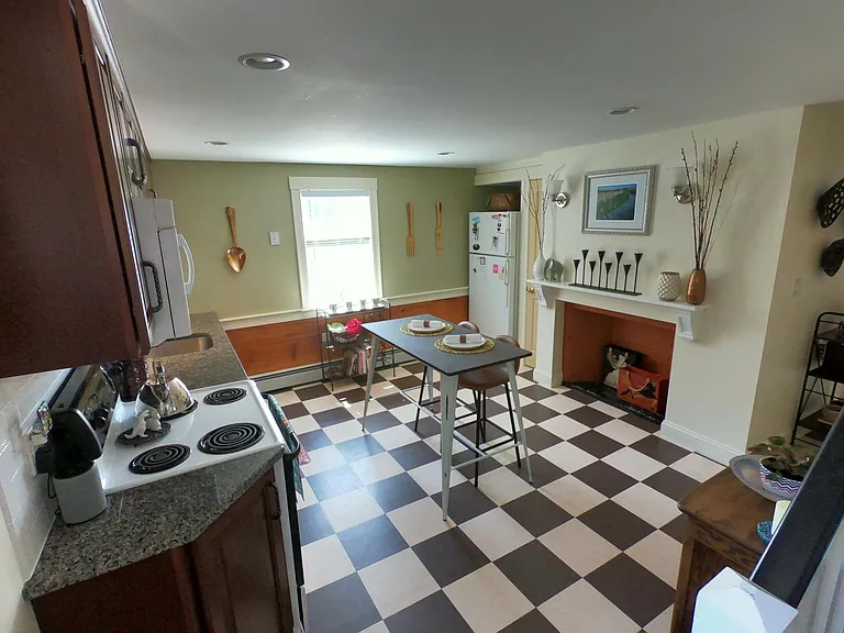Eat in kitchen with decorative fireplace and barn board wainscoting (shown prior to recent repainting).