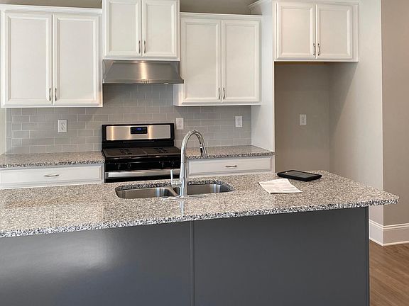 Stainless appliances, granite counters, stylish white cabinets with contrasting island.