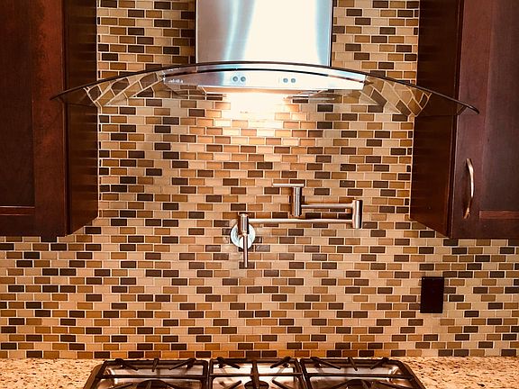 Updated kitchen, features gas cook top and desirable "pot filler" faucet - and dramatic exhaust fan.