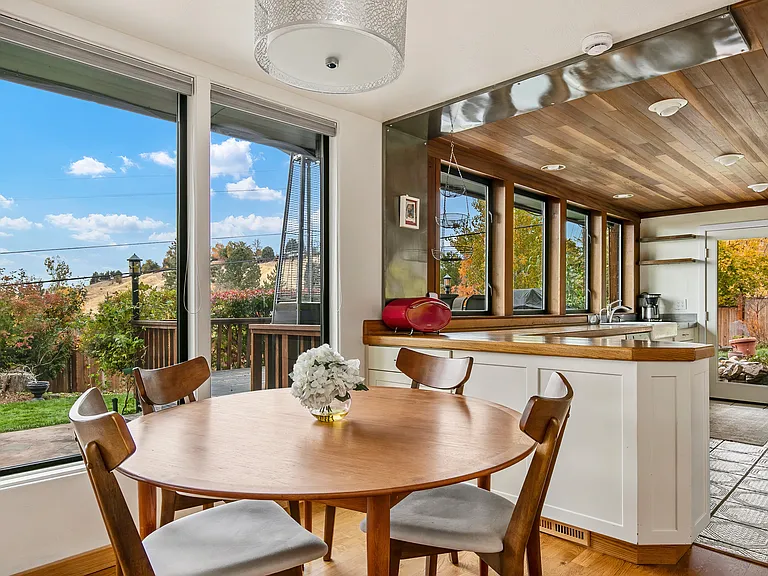 Dining area with expandable table. Large windows throughout.