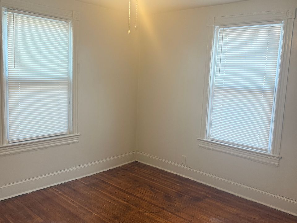 large living room four windows with hardwood floors