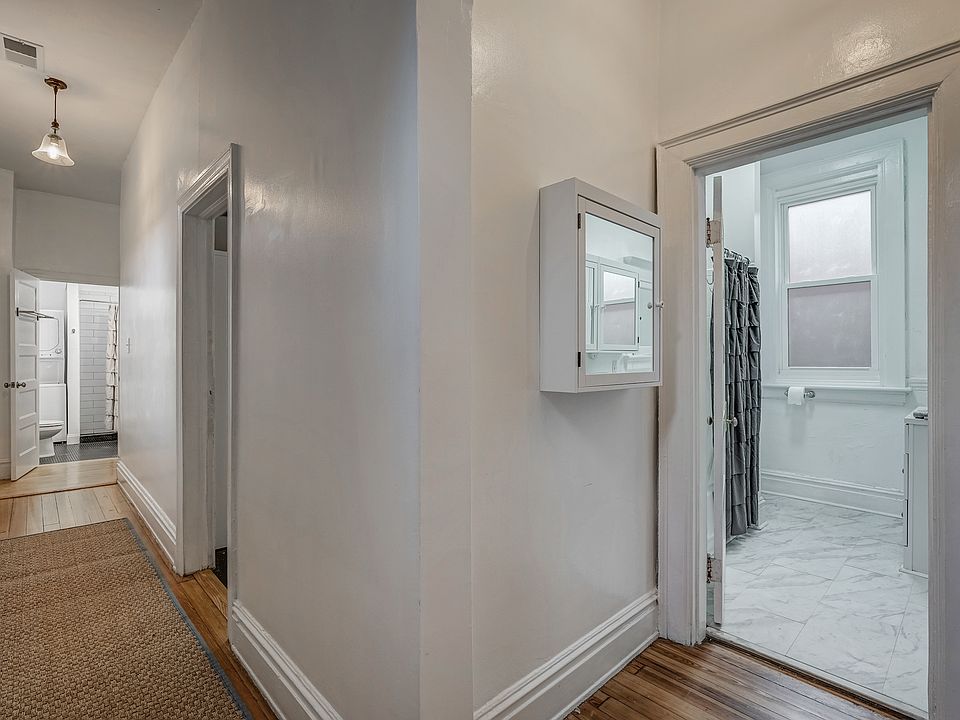 Two full bathrooms. Long hallway separates bedrooms from living room, dining room, and kitchen.