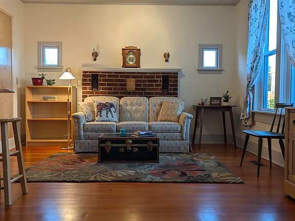 The living room is comfortable with a couch, chair, tv and great light from the large east facing windows.
