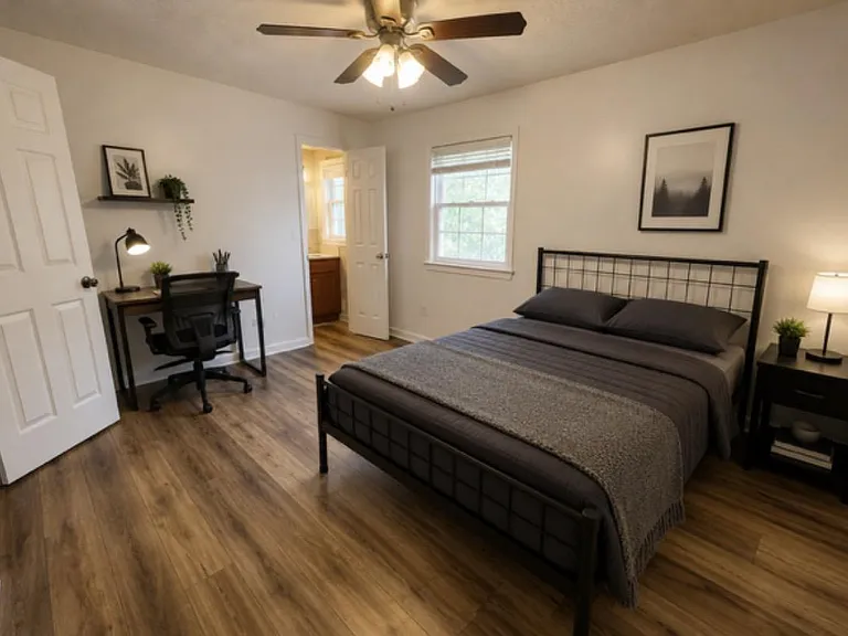 large primary suite bedroom with private on suite bathroom, small desk work station, large closet, queen bed, and on the mai