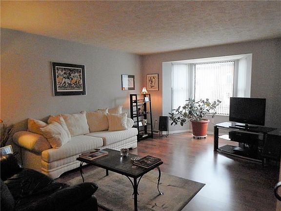 LIVING ROOM WITH LOVELY BAY WINDOW AND LAMINATE FLOORING.
