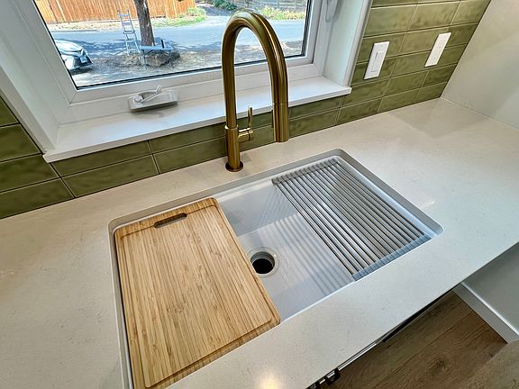 Deep sink with drying mat and cutting board.