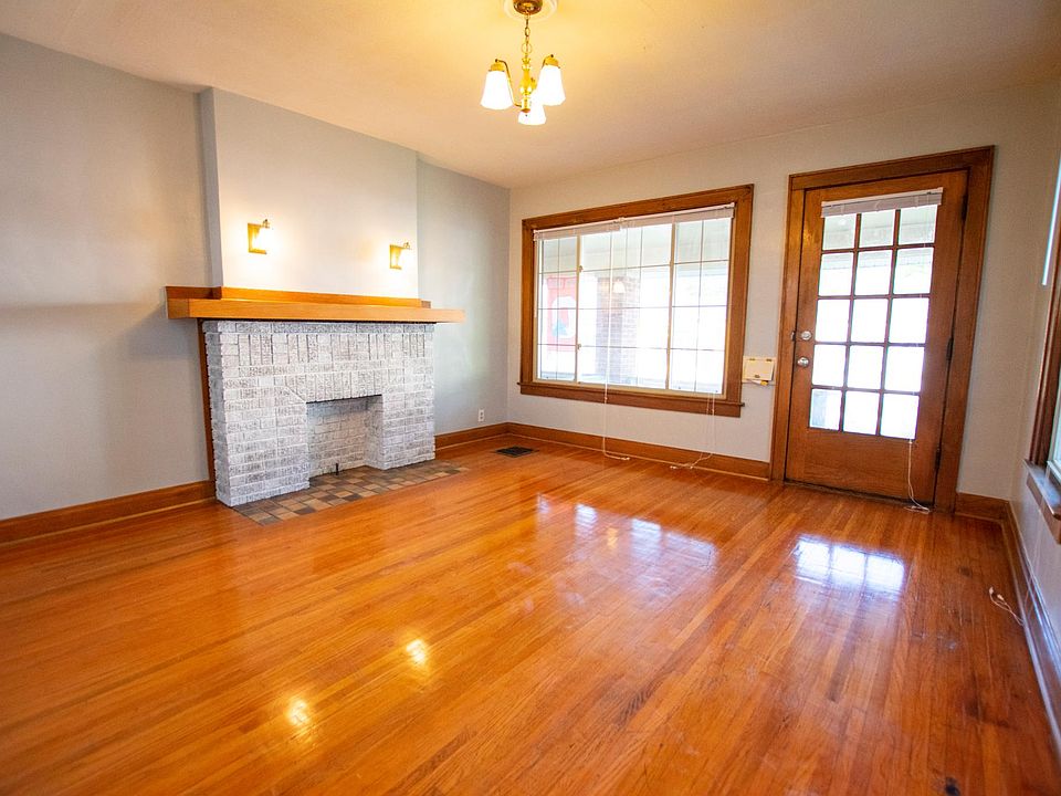 Front door opens into a spacious living room with large windows and natural, bright lighting.