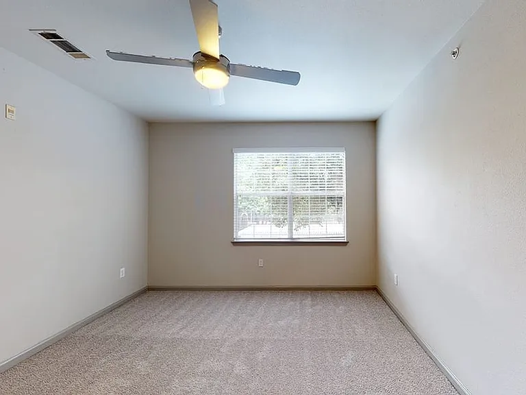 Spacious apartment bedroom with plush carpet flooring