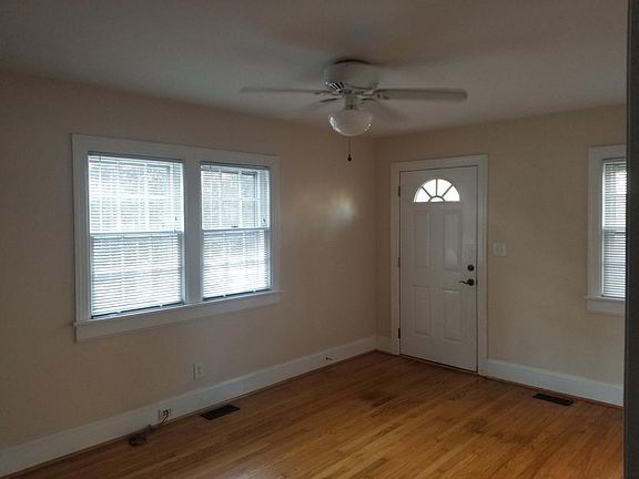 Living room with hardwood floors, big windows, and a ceiling