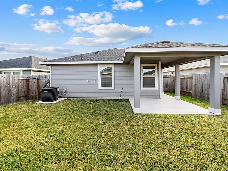 Spacious fenced in backyard with a covered patio