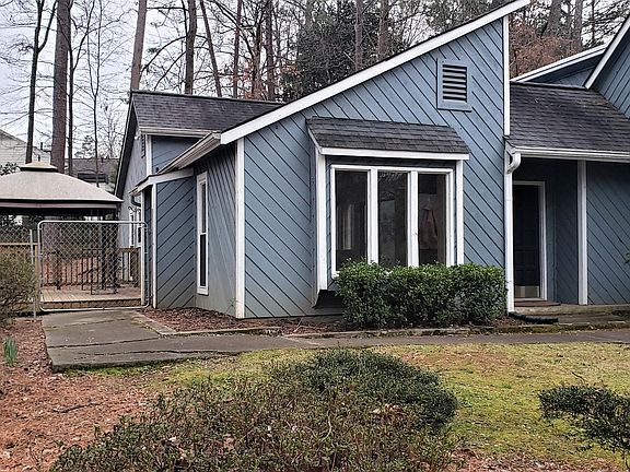 Front and side view. Chain-link fencing surrounds side and back yards.