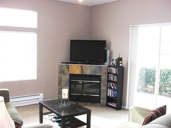 Relax in living room with gas fireplace & glass slider leading to covered patio
