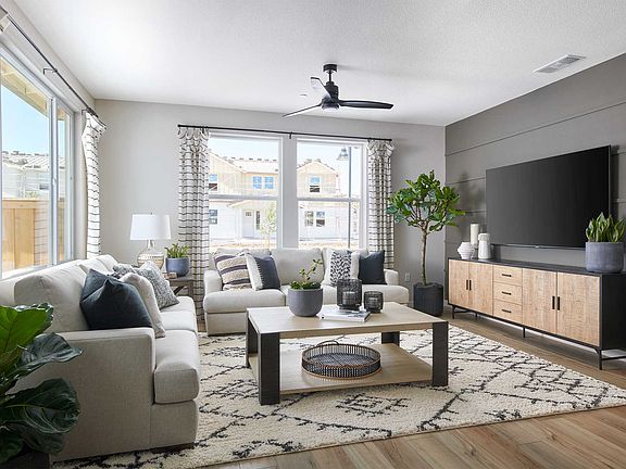 A cozy and modern living room with a gray sofa, a wooden coffee table, and a large TV stand, surroun
