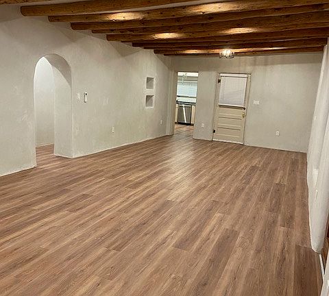 View of the living/dining area and arched entry to the master bedroom, guest bedroom, and guest bathroom.