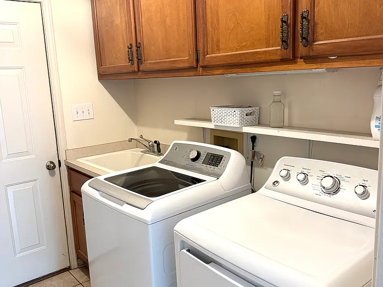 Laundry room with storage and half bathroom