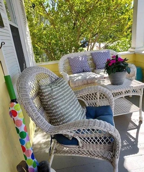 cozy covered rocking-chair front porch with rock, swing, and wicker seating area (and umbrellas:)