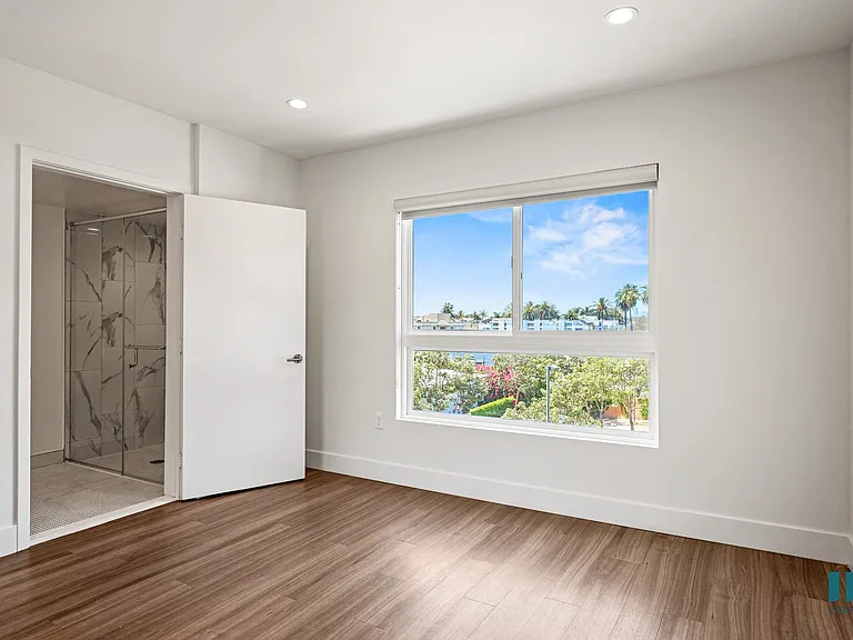Bedroom with Large-Windows, Vinyl Flooring, Recessed Lighting, and Bathroom