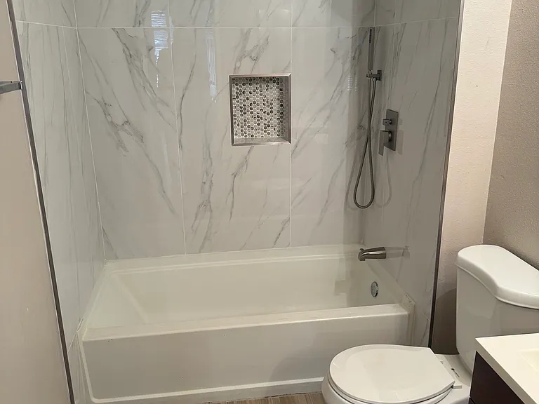 Guest bath with tub and overhead shower.