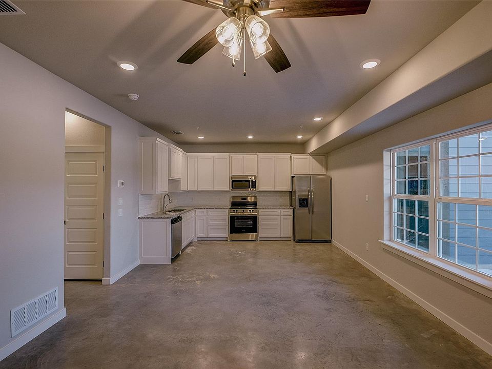 Extremely large living area with a ceiling fan, lots of windows, great kitchen spance