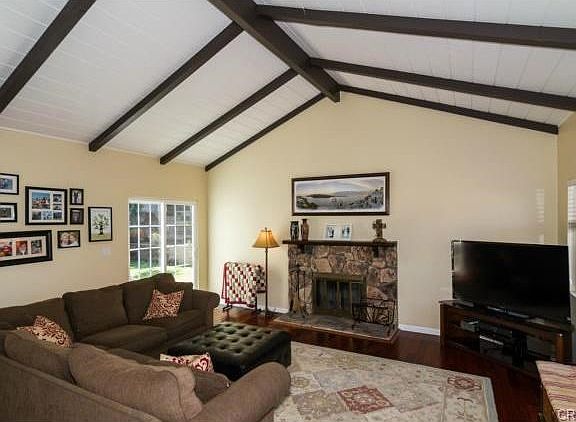 Spacious living room has vaulted ceilings and opens up to the ba