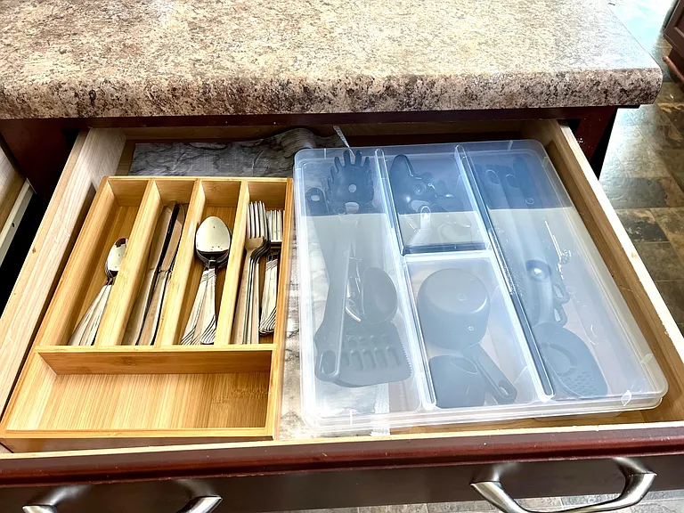 Kitchen storage drawer with organized utensil and flatware trays for easy meal prep and everyday convenience.