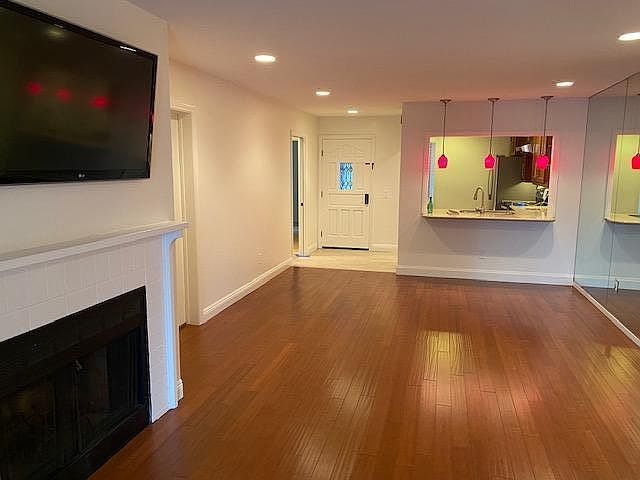 LIVING ROOM INCLUDES A MOUNTED TV OVER A REAL FIREPLACE (cable ready). Approximate room dimensions are 25' x 13'