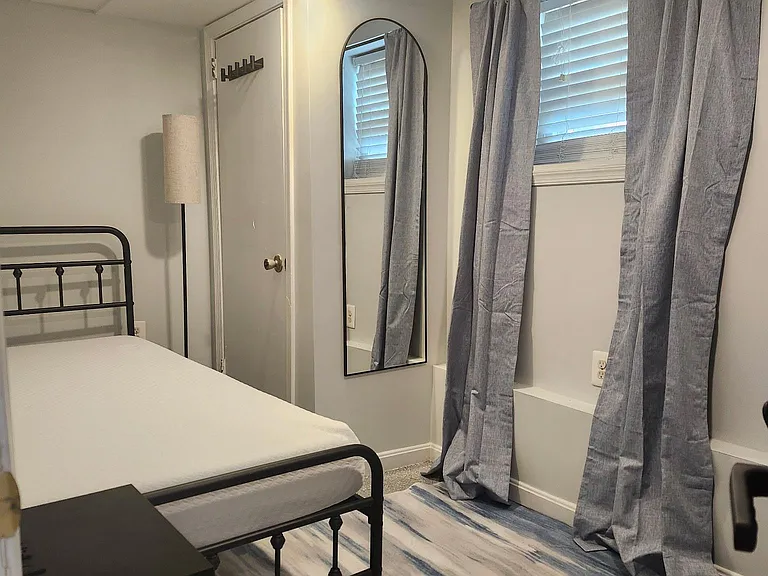 Twin bed with closet, mirror, and nigbtstand.