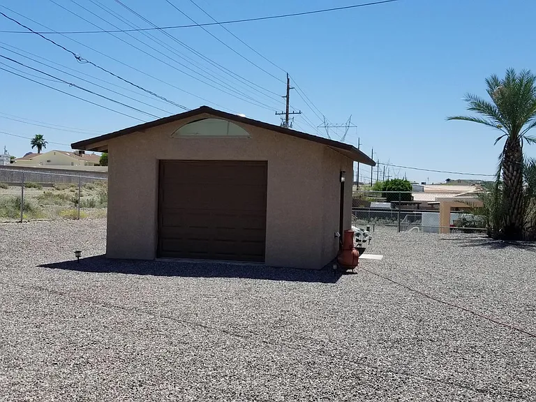 16 x 20 back garage/hobby room with storage cabinets, work space and electricity, and roll up door for atv parking if desired