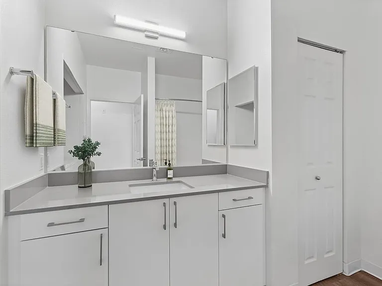 Renovated Package I bath with white cabinetry, grey quartz countertops, and hard surface flooring