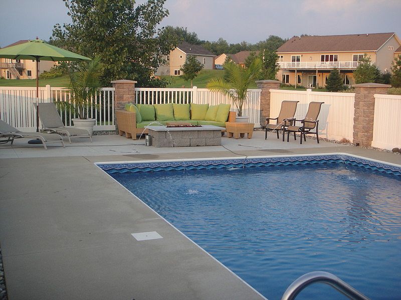 Pool Deck : Large Concrete pool deck with extended seating area and Fireplace at end of pool
