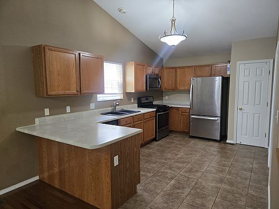 Kitchen featuring microwave, stove, refrigerator, disposal, dishwasher