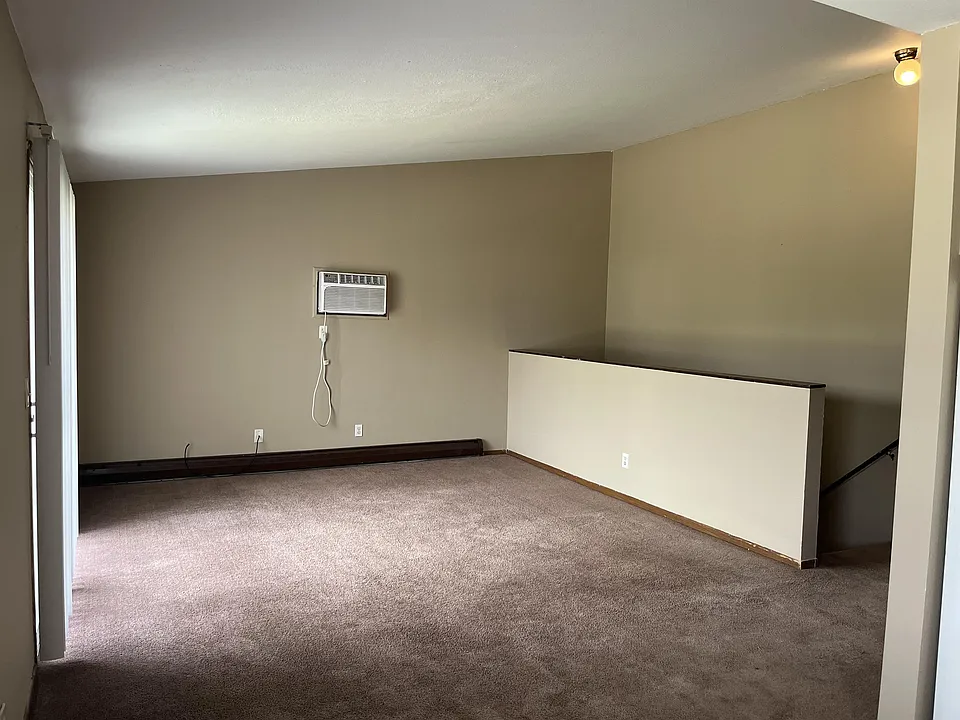 Large living room with vaulted ceilings. Slider and deck on the left