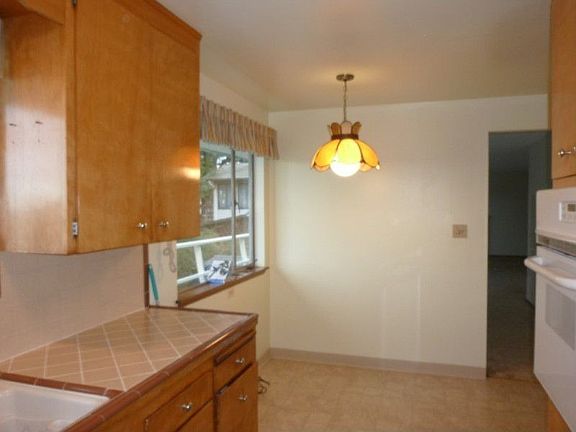 Kitchen eating space with wonderful outlook to back yard and peek Puget Sound & Vashon Island view.