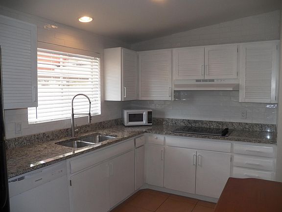 Beautifully remodeled kitchen, cooktop stove, kitchen island, wall oven, pantry, dishwasher, microwave, double sinks