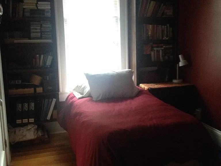 This room has been painted white, and the brown bookshelves have been taken down. There is a Jack-and-Jill bathroom between the two bedrooms.