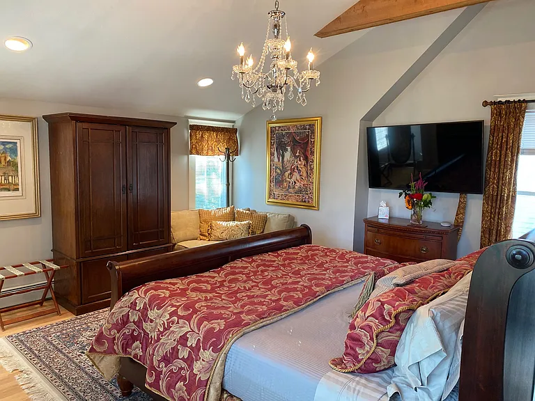 The primary bedroom with vaulted ceiling above a luxury king bed.