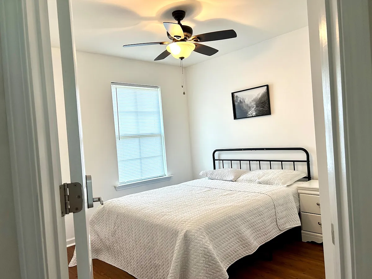 Private bedroom with a full-size bed, ceiling fan with light, and a window with blinds for easy light control. - Shepherd Valley St