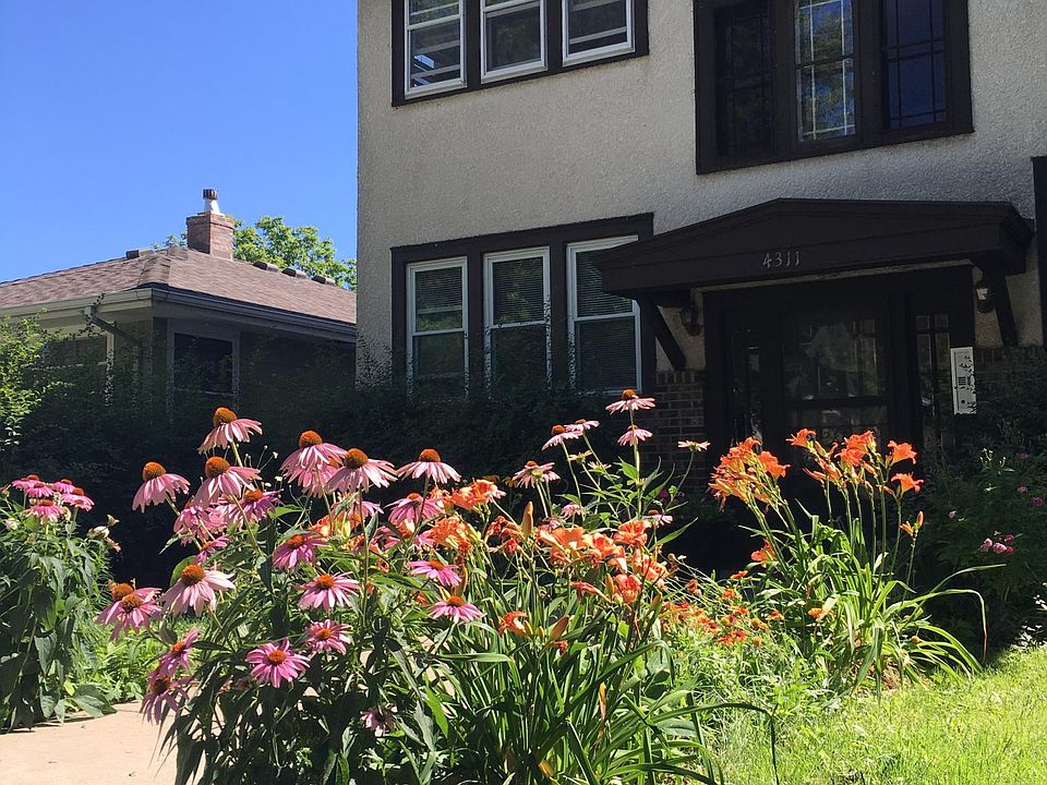 Front of building w/ perennial gardens along the walk.