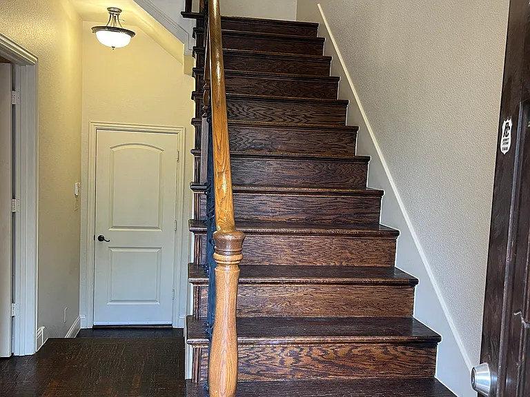 Wooden stairs to second floor, main living room and kitchen area